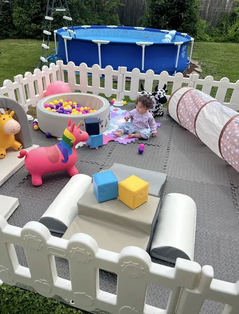 Backyard soft play setup with a ball pit, tunnel and ride-on unicorn