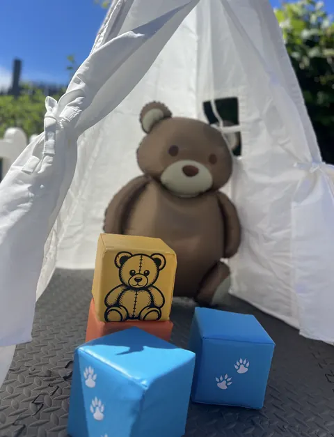 White teepee with a teddy bear and soft blocks