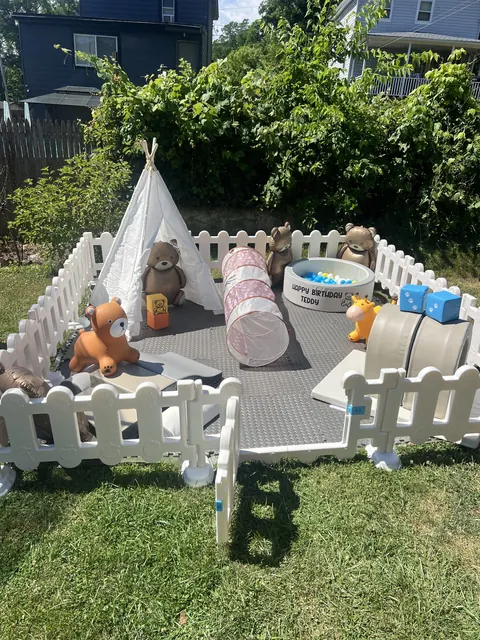 Themed outdoor soft play setup with a teepee, teddy bears and ball pit